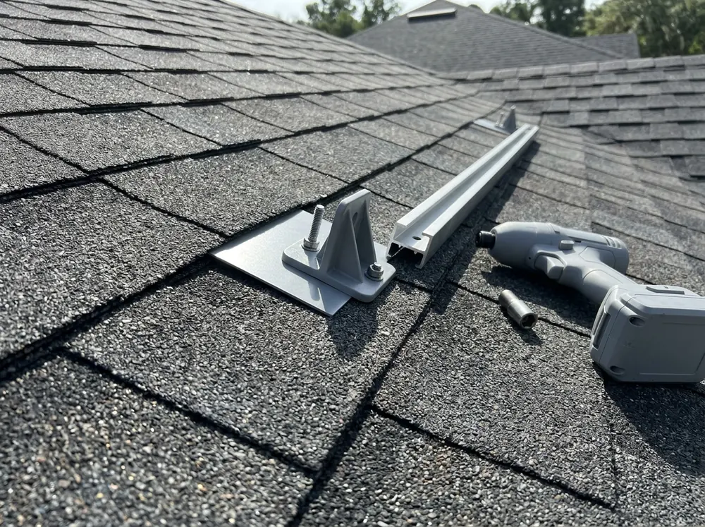 Flashed solar mounting foot fastened through new architectural shingles before the rails go back on